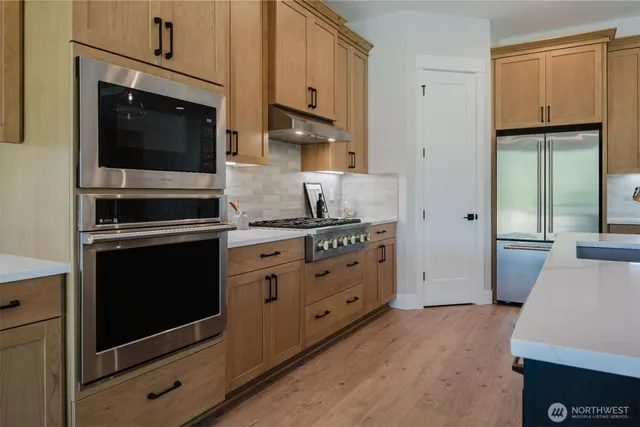 a kitchen with stainless steel appliances a stove microwave and sink