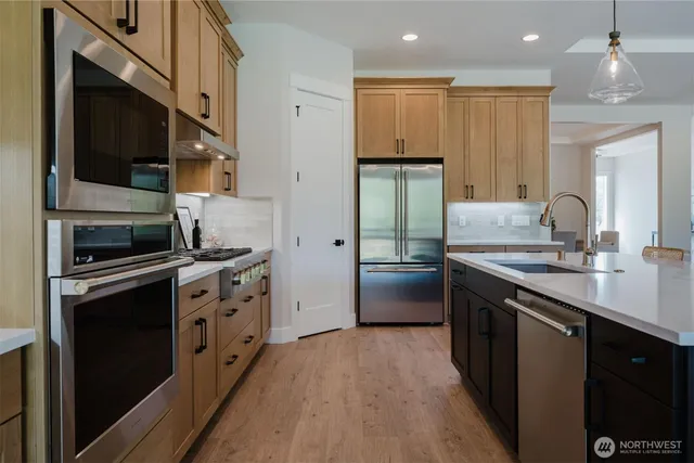a kitchen with stainless steel appliances a sink stove and refrigerator
