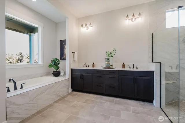 a spacious bathroom with a tub sink and mirror