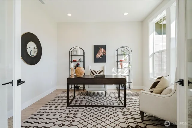 a living room with furniture a clock on wall and a window