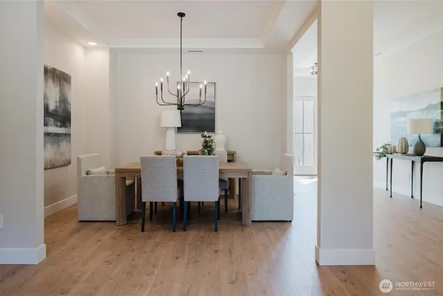 a view of a dining room and livingroom with furniture wooden floor a chandelier
