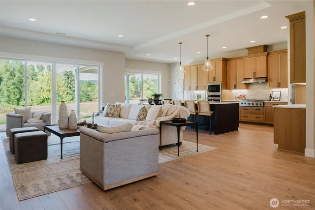 a living room with furniture kitchen and a large window