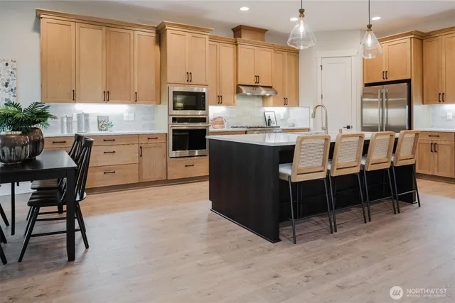 a large kitchen with kitchen island a dining table and chairs