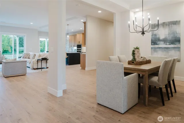 a dining room with furniture a chandelier and wooden floor