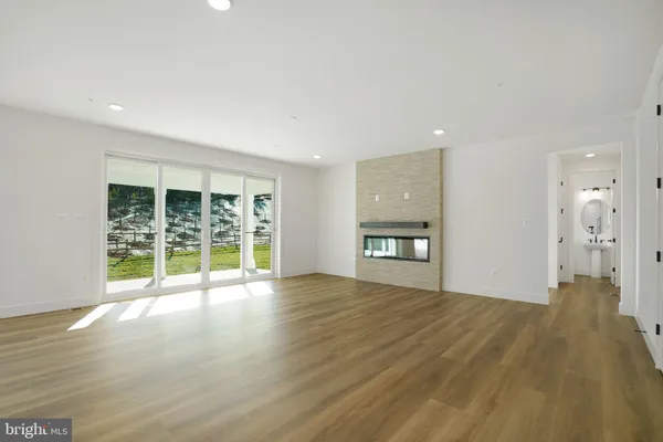 a large white kitchen with kitchen island a stove a refrigerator a sink dishwasher with a dining table and chairs with wooden floor