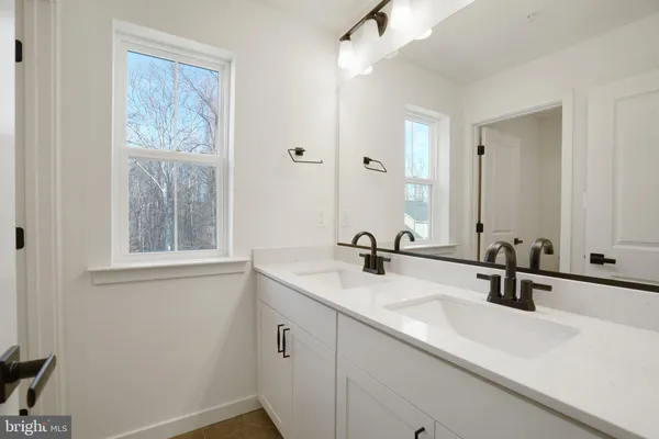 a bathroom with a double vanity sink a mirror and next