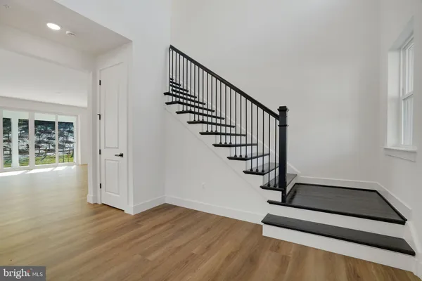 a view of a hallway with wooden floor and staircase