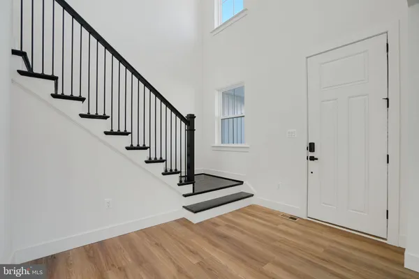a view of a hallway with wooden floor and entryway