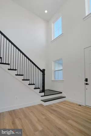 a view of an empty room with wooden floor and windows