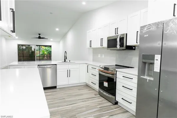a kitchen with white cabinets and stainless steel appliances