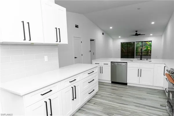 a kitchen with white cabinets and white appliances