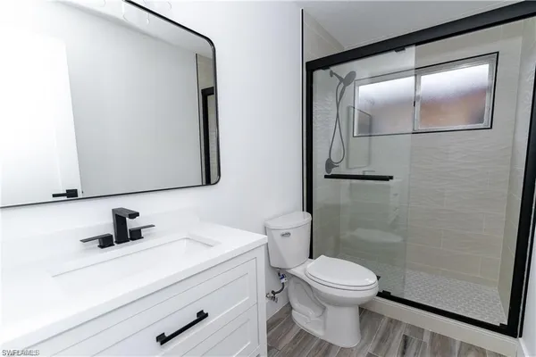 a bathroom with a toilet a sink and mirror