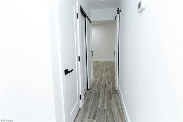 a view of a hallway with wooden floor