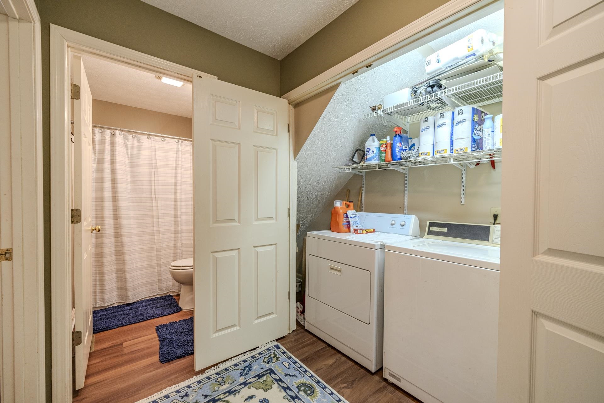 435 Murray Lane Counce, TN 38326 - Photo 21 of 34 Dedicated laundry area featuring a washer and dryer, integrated shelving, and wood-finish flooring