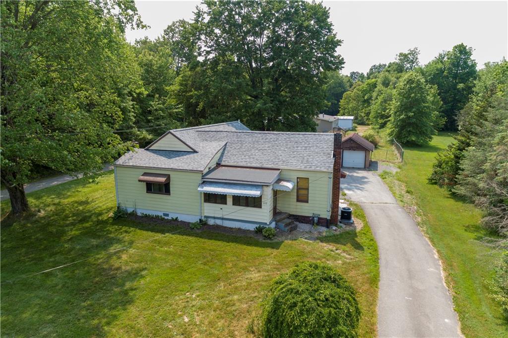 a aerial view of a house with a yard table and chairs