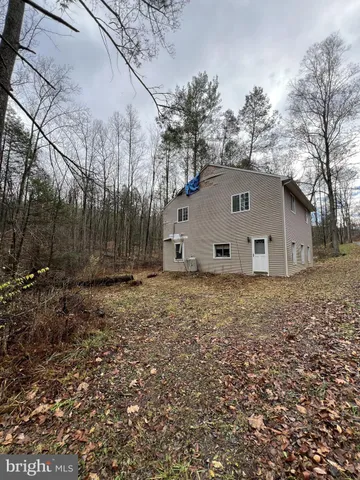 a house is sitting in middle of the forest