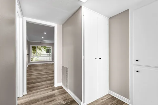 a view of a hallway with wooden floor and closet