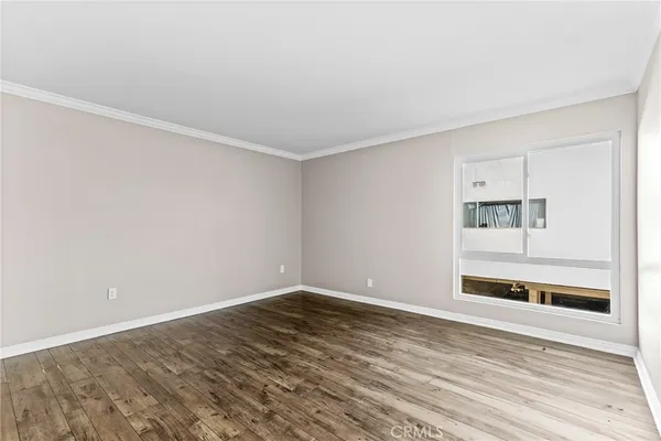 a view of an empty room with wooden floor