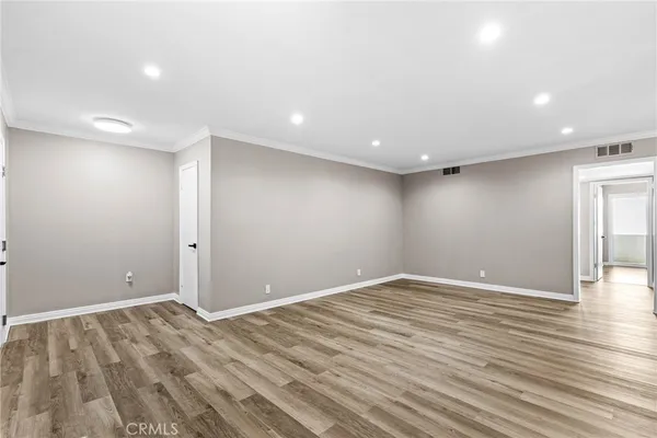 a view of empty room with wooden floor