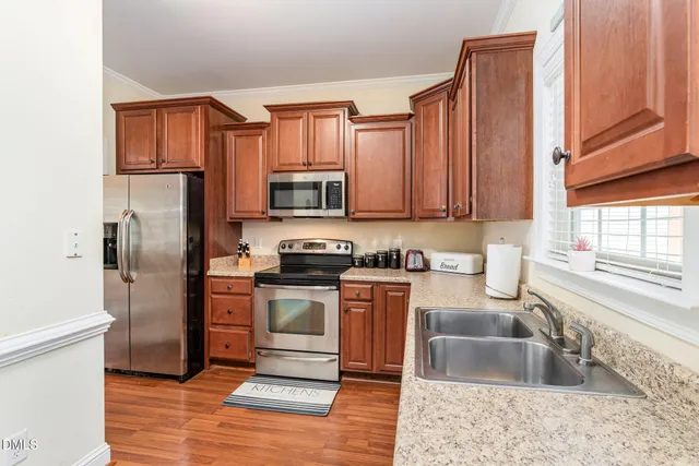 a kitchen with stainless steel appliances granite countertop a refrigerator stove and sink