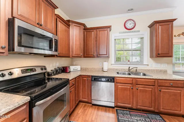 a kitchen with stainless steel appliances a stove sink microwave and cabinets