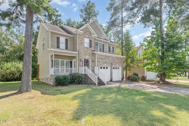 a view of a house with backyard and tree