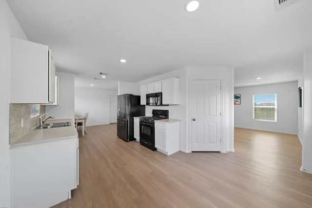 a kitchen with stainless steel appliances kitchen island granite countertop a sink and cabinets