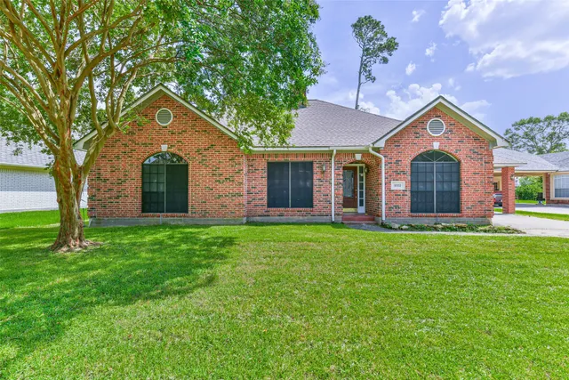 a front view of a house with yard and green space