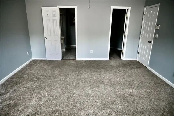an empty room with closet and mirror