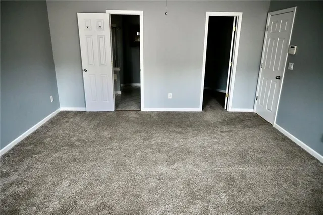 an empty room with closet and mirror