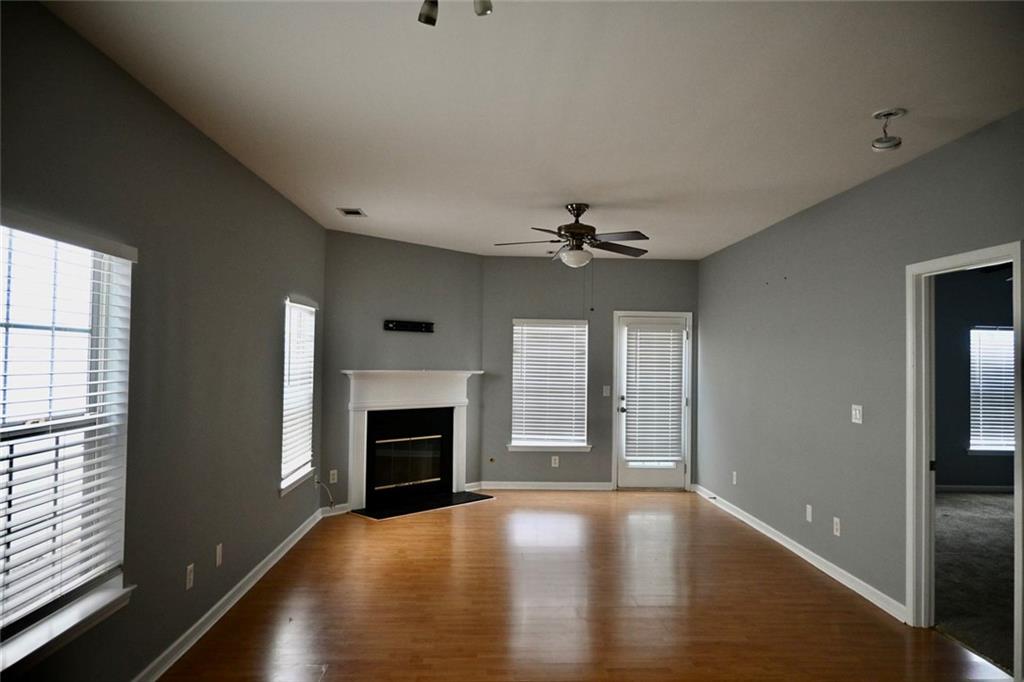 1563 Rachel's Ridge Northwest Kennesaw, GA 30152 - Photo 2 of 29 an empty room with windows fireplace and wooden floor