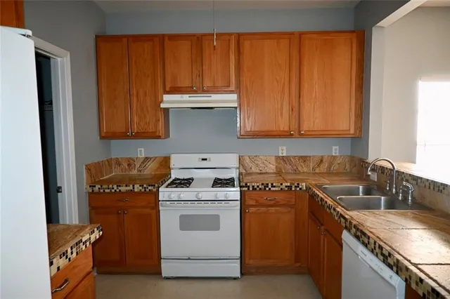 a kitchen with a sink stove and cabinets