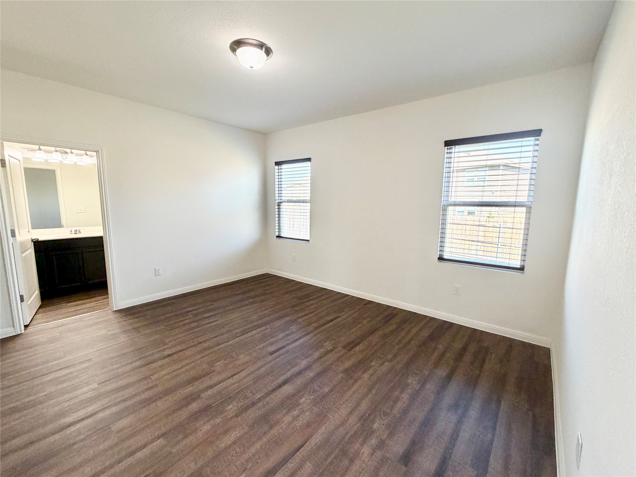 360 Bell Rings Drive Jarrell, TX 76537 - Photo 5 of 10 Two windows allow ample natural light into this quiet bedroom with rich wood flooring.