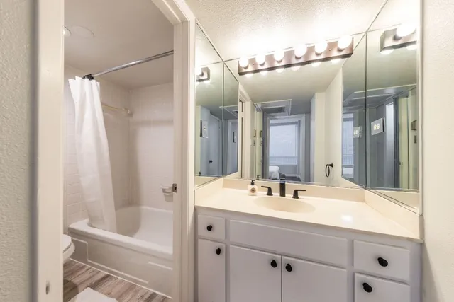 a bathroom with a double vanity sink mirror and shower