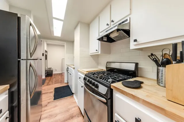 a kitchen with a stove a refrigerator and a sink