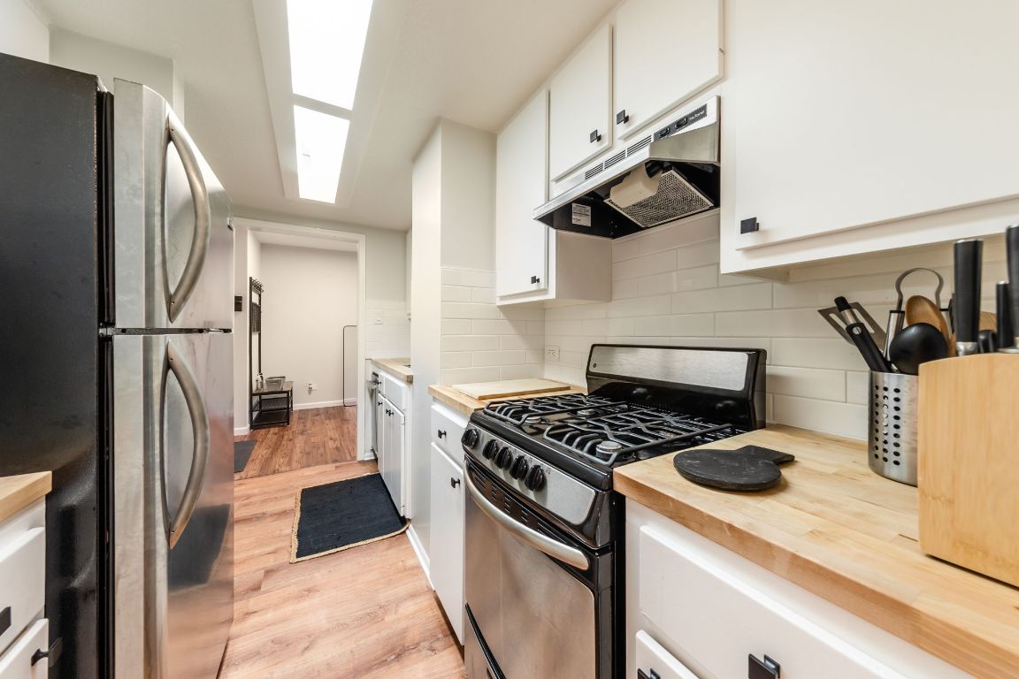 1212 Guadalupe Street, Unit 301 Austin, TX 78701 - Photo 18 of 28 a kitchen with a stove a refrigerator and a sink