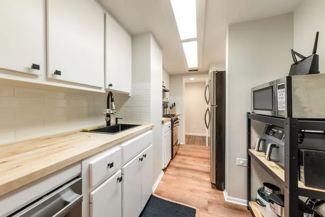 a kitchen with stainless steel appliances a sink and a refrigerator