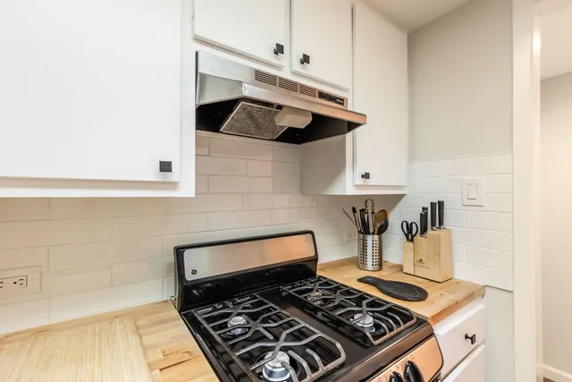 a stove top oven sitting inside of a kitchen