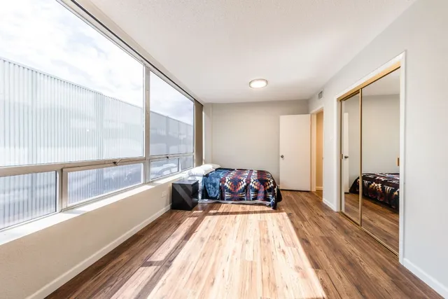 a spacious bedroom with a bed and a large window