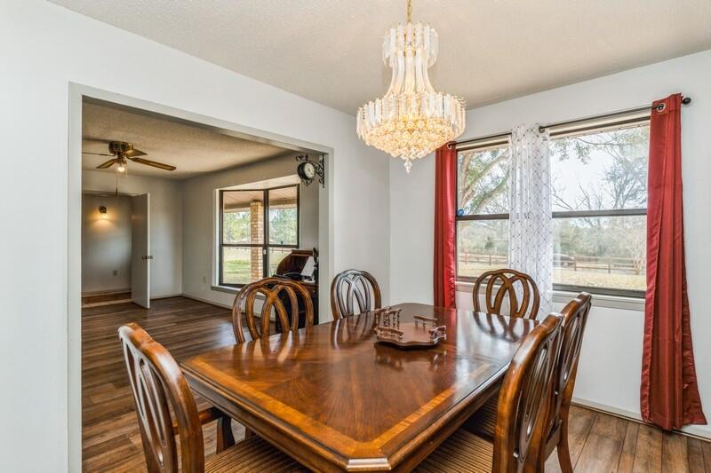 6246 Holloway Road Baker, FL 32531 - Photo 17 of 52 a view of a dining room with furniture a chandelier and wooden floor