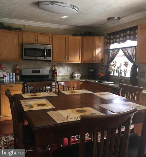 1403 Bretton View Road Annapolis, MD 21409 - Photo 14 of 30 a kitchen with a table chairs microwave and cabinets