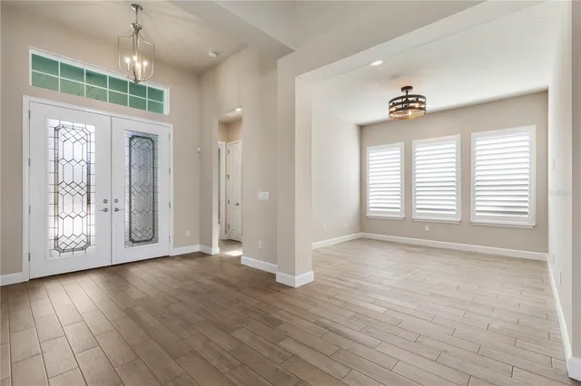 a view of kitchen with stainless steel appliances granite countertop a refrigerator a sink dishwasher a oven and a dining table with wooden floor