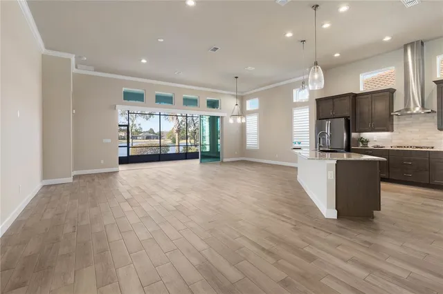 a kitchen with stainless steel appliances granite countertop a sink a stove a refrigerator and island with wooden floor