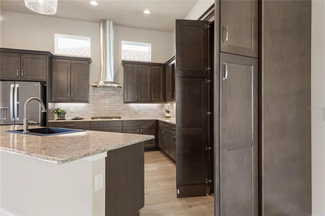 a view of kitchen with stainless steel appliances granite countertop a refrigerator and a stove top oven