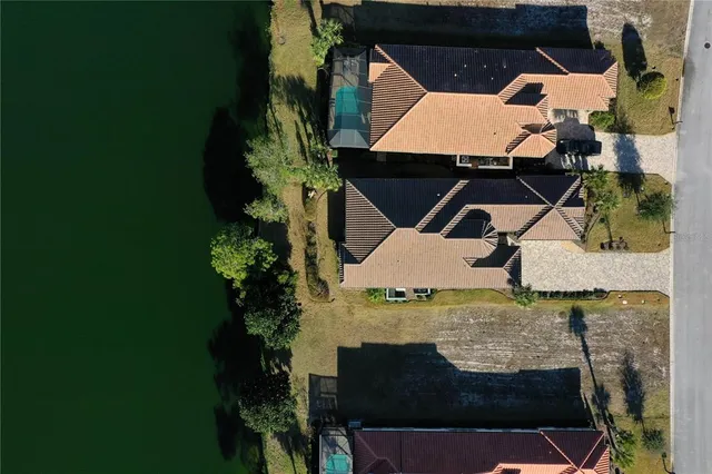 an aerial view of residential houses with outdoor space and trees all around