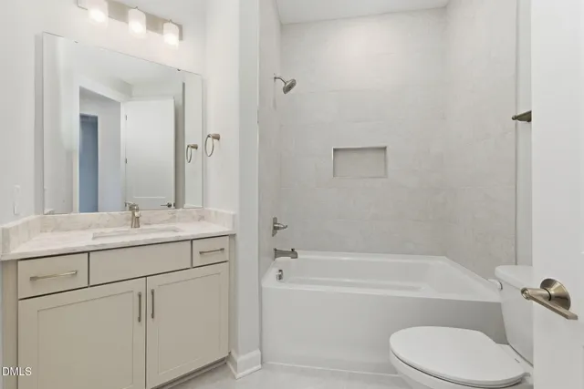 a bathroom with a granite countertop toilet a sink and bathtub