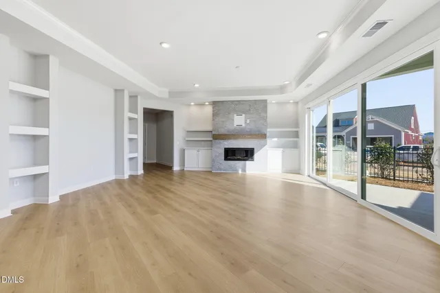 a view of empty room with wooden floor and fireplace