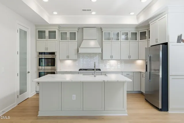 a kitchen with kitchen island granite countertop a stove and a refrigerator