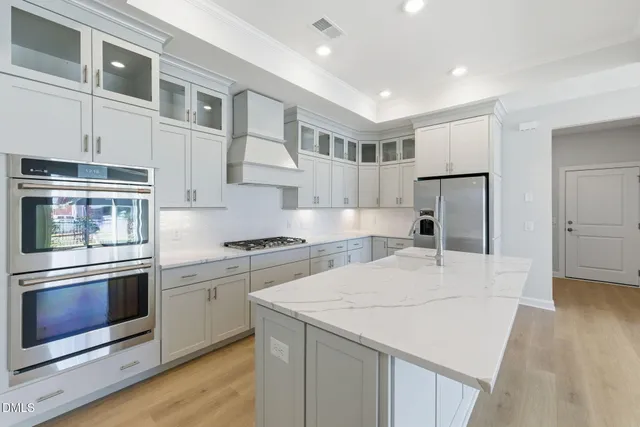 a kitchen with stainless steel appliances granite countertop a stove a refrigerator and a microwave