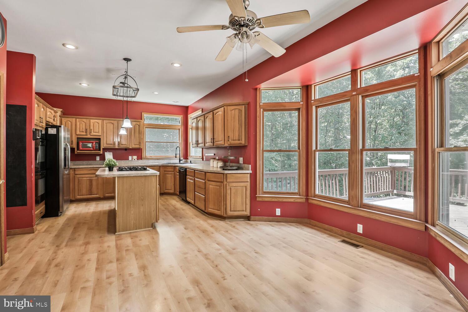1761 Buckner Road Bumpass, VA 23024 - Photo 11 of 43 a kitchen with stainless steel appliances kitchen island granite countertop a refrigerator a sink and wooden cabinets